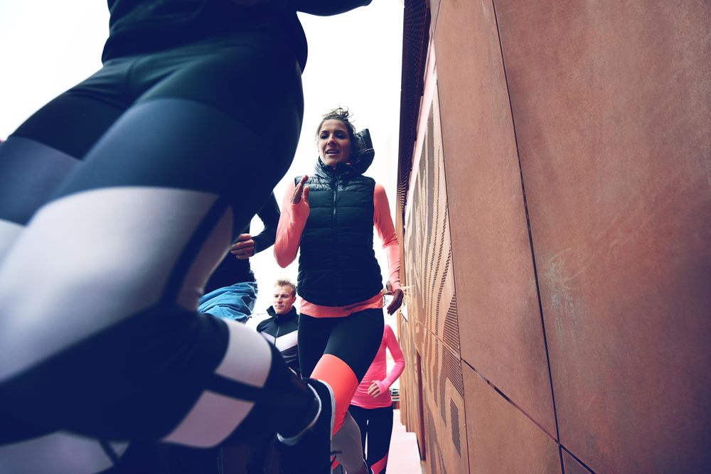 Group of people running close to a wall