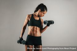 Woman with toned muscular body lifting weights 5pgPdO