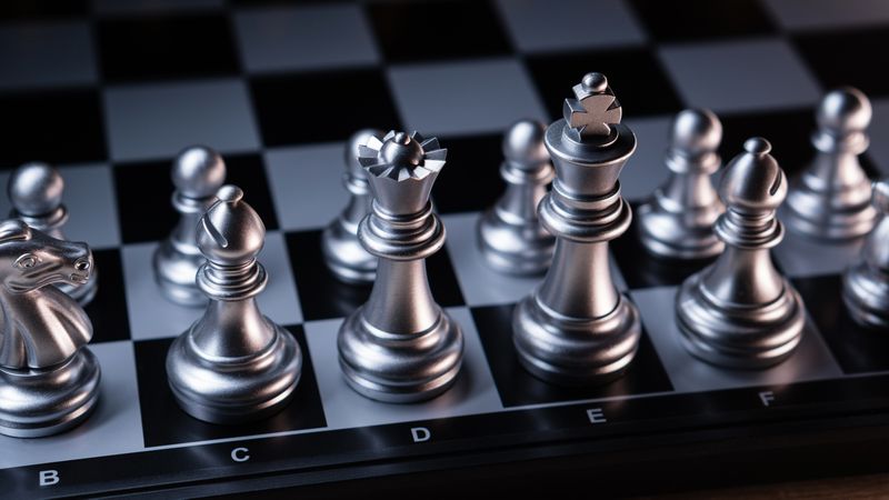 Strategically arranged silver chess pieces, wide angle.