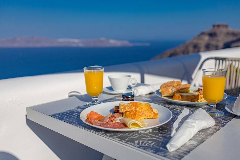 Morning fresh juice and breakfast with blue sea view in Greece