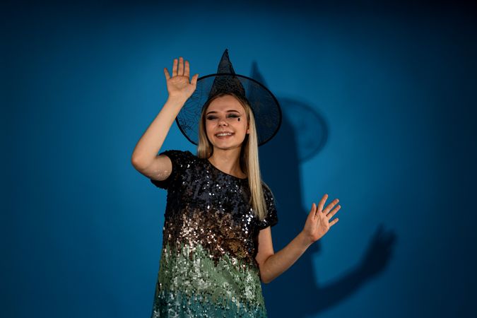 A woman in a Halloween costume is dancing at a party, on a blue background