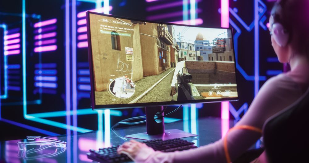 Professional eSports Gamer Playing 3D First Person Shooter Video Game with Fast Fun Action on Desktop Computer.