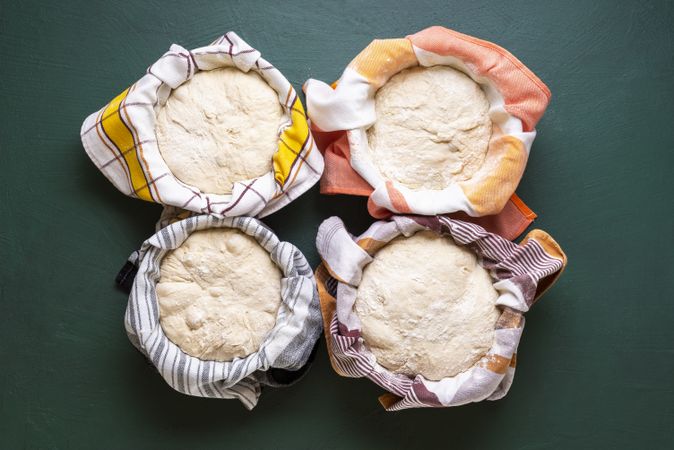 Above view of sourdough resting in bowls on a green table