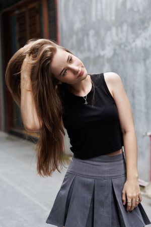 Portrait of young woman smiling and touching her hair