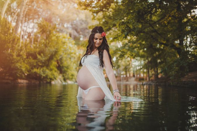 Pregnant woman standing in lake water