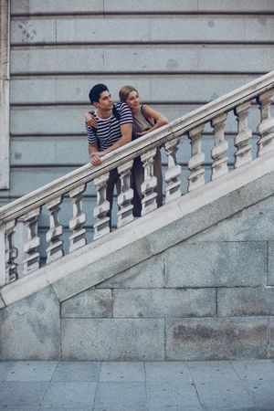Young couple standing on ancient stairs against wall