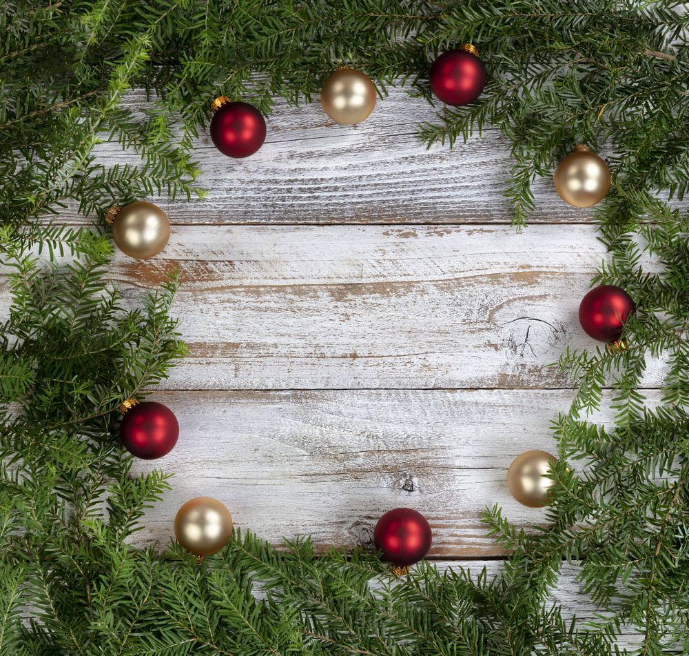 Real fir wreath with gold and red ball ornaments on rustic wood for the Christmas or New Year holiday background