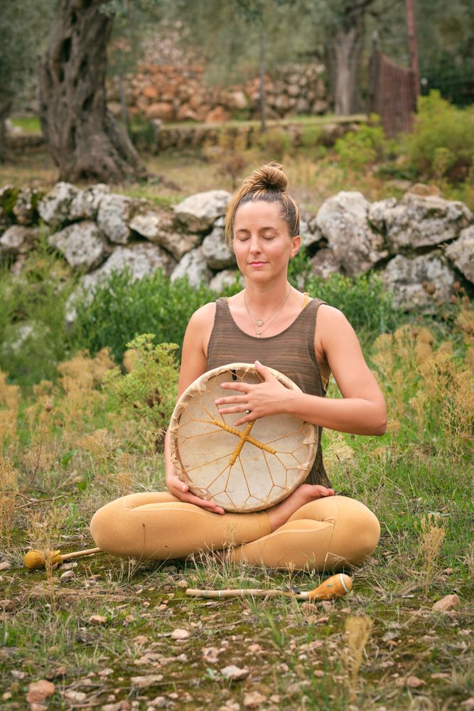 Woman meditating with tambourine in park