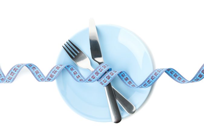 Cutlery with measuring tape isolated on blank background
