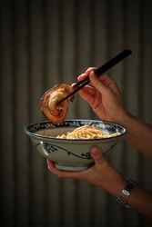 Unrecognizable person holding bowl with Asian food