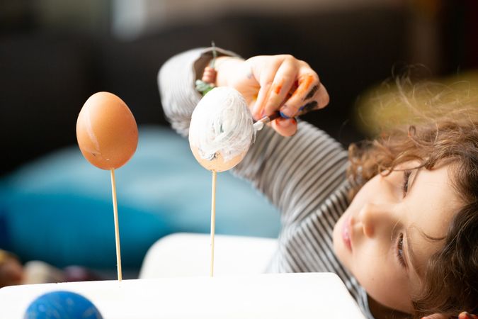 Girl painting eggs at home