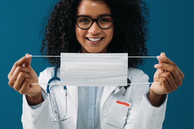 Close up of a female doctor holding a mask in her hands