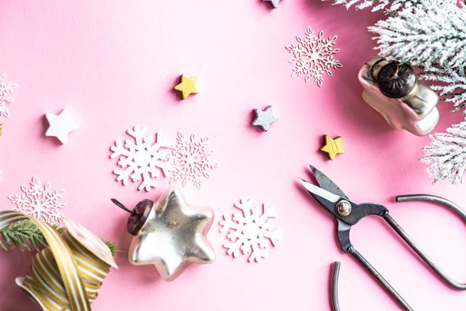 Top view of Christmas decorations of snowflakes and stars on pink background