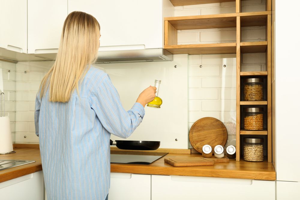 Young woman cooking something in kitchen with modern interior
