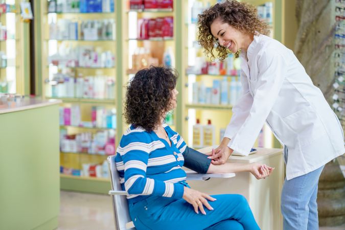 Woman having blood pressure taken at pharmacy
