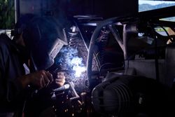 Male mechanic welding motorcycle parts