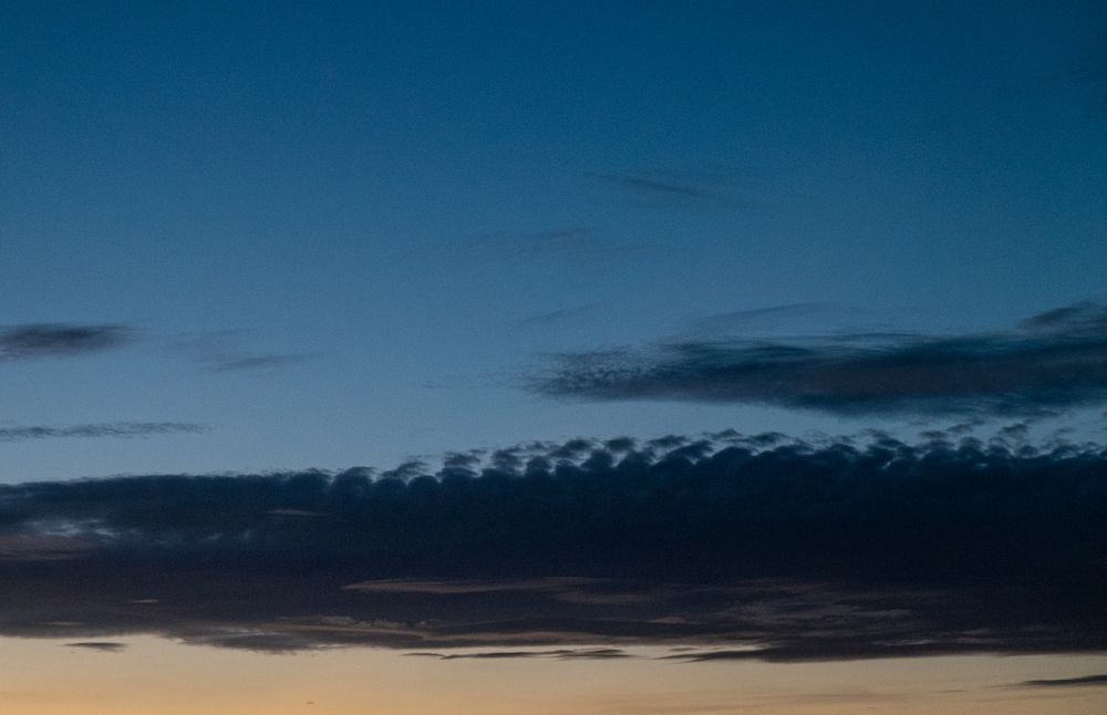 Long grey clouds in blue sky
