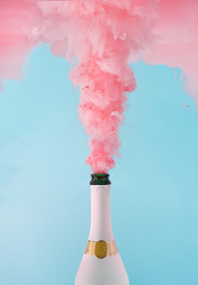 Pastel pink champagne explosion on blue background