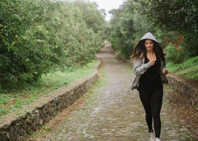 Positive woman running in park
