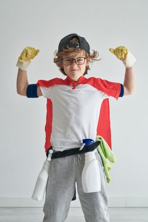Cheerful boy showing biceps in studio