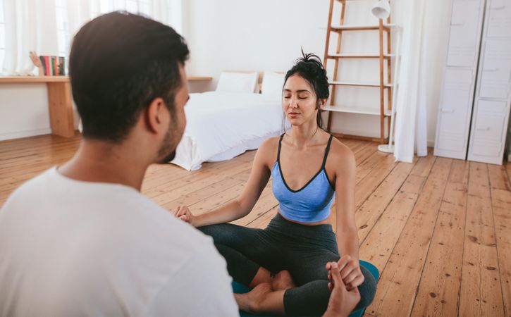 Relaxed woman sitting in yoga pose with her partner