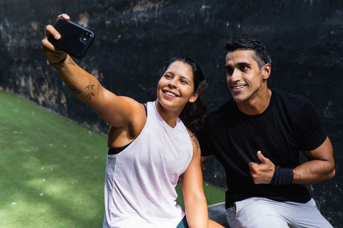 Smiling couple taking selfie on smartphone during training