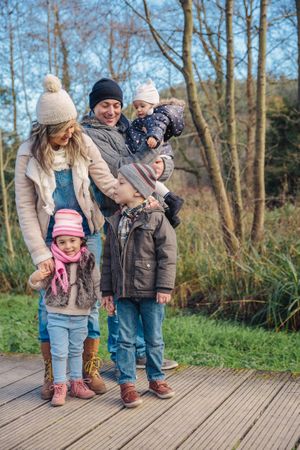 Happy family standing on trail in forest in fall