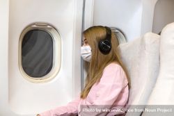 Female passenger in airplane leaning on cabin wall bxyBd0