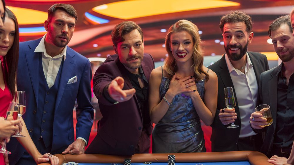Croupier Placing a Ball into the Wheel, Focused on Table with Tokens, while Ball Spins on the Ball Track