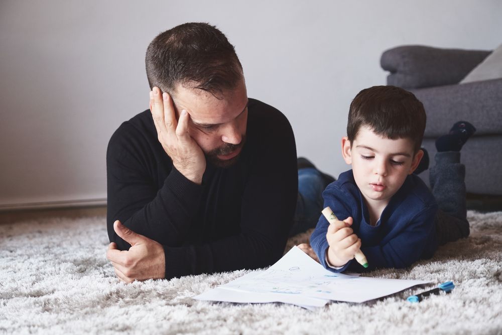 Father and son drawing on floor