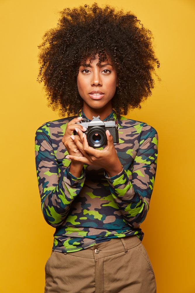 Trendy female paparazzi holding camera
