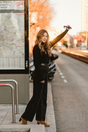 Cheerful woman hailing taxi