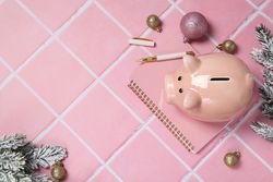 Piggy bank, Christmas decor and notepad on pink background, space for text