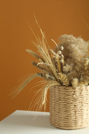 Beautiful dried floral arrangement in wicker basket, vertical composition