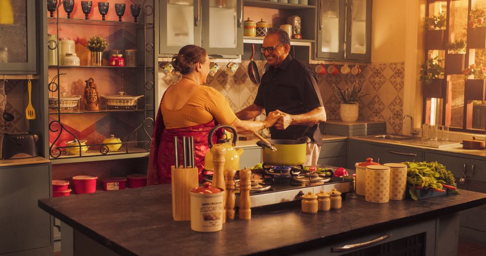 Happy Mature Couple Dancing and Having Fun in the Kitchen: Celebrating Life, Vitality and Anniversary.