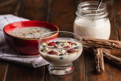 Yogurt in glass bowl with berries and cinnamon sticks