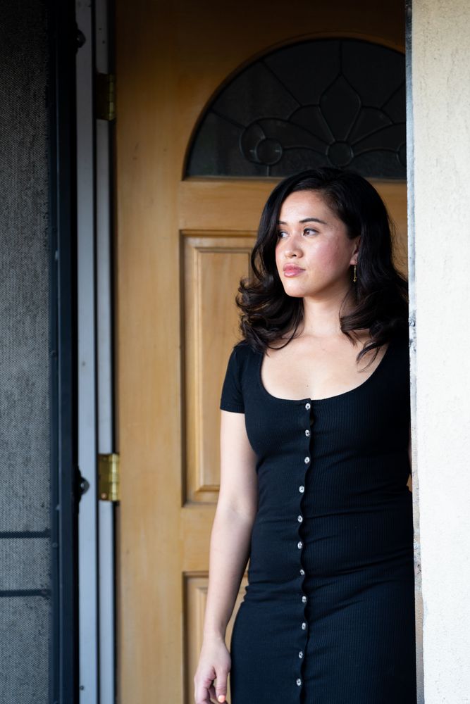Beautiful woman in dark dress looking out of her doorway
