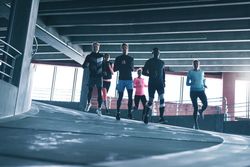 Group of sporty people running down a decline