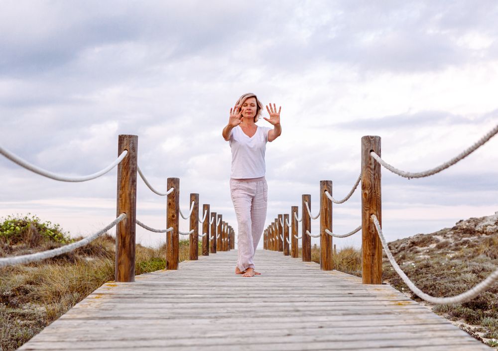 Barefoot woman exercising on wooden path