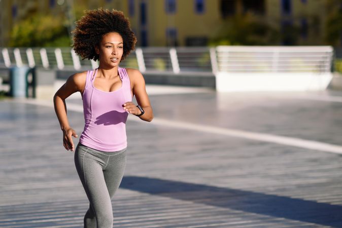 Woman with afro hairstyle running outside