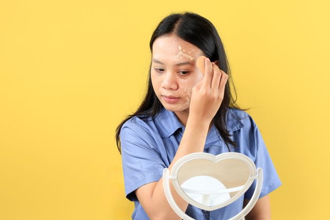 Young Asian Girl Applying Foundation using Beauty Blender