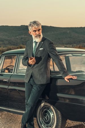 Man in suit standing beside car