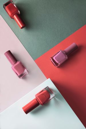 Multi-colored nail polish on pastel colors geometric pattern background