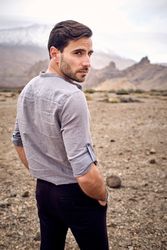 Positive man standing in nature on dry rocky terrain