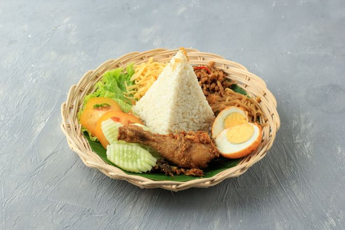 Pyramid of rice in center of nasi uduk breakfast meal
