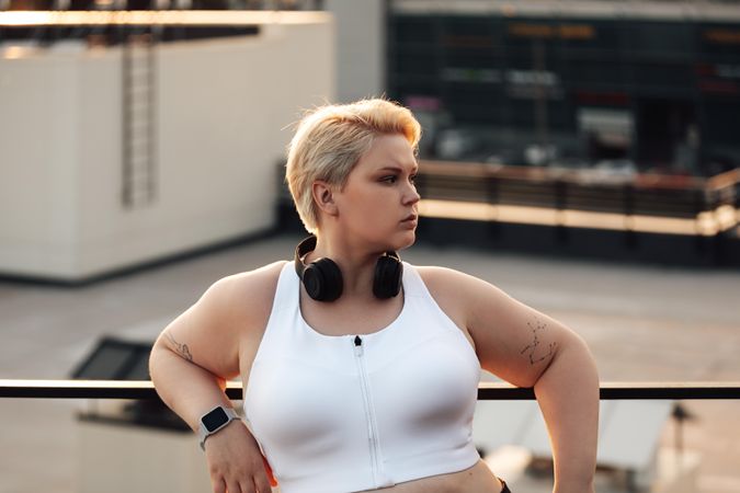 Woman leaning to a railing during a workout on a roof