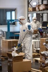 Two me in PPE sanitizing warehouse during lockdown