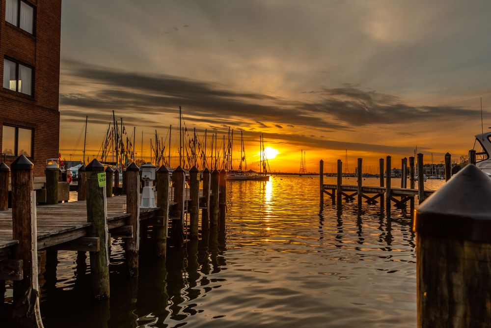 Silhouette of dock on sea during golden hour