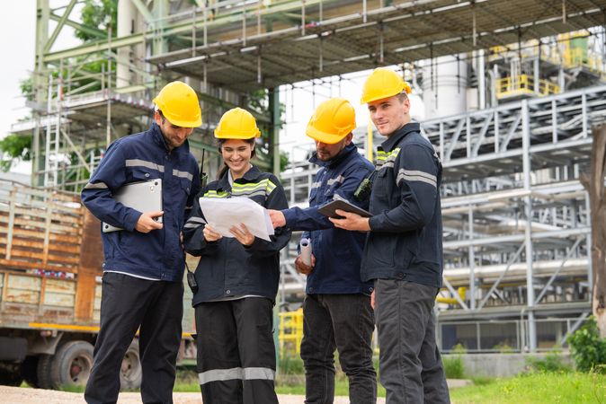 Group of engineer workers checking project at petrochemical factory or refinery oil plant industrial.