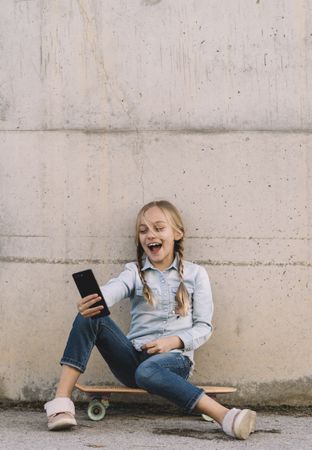 Kid using mobile phone with skate